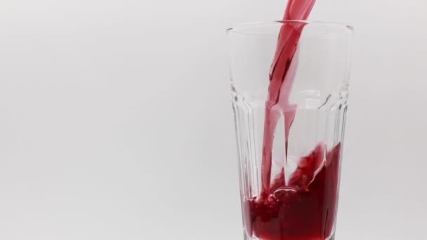 Versare Succo Melograno Bicchiere Rotante Uno Sfondo Bianco — Video Stock