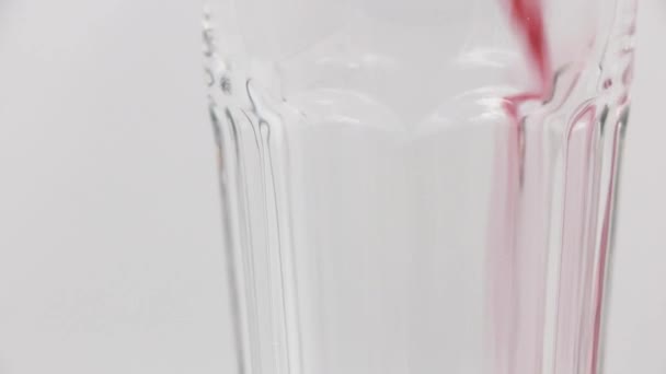 Versare Succo Melograno Bicchiere Rotante Uno Sfondo Bianco — Video Stock