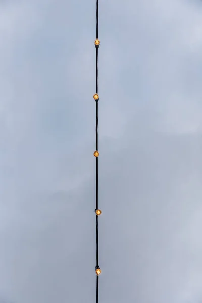 Žárovkové věnce proti šedé obloze — Stock fotografie