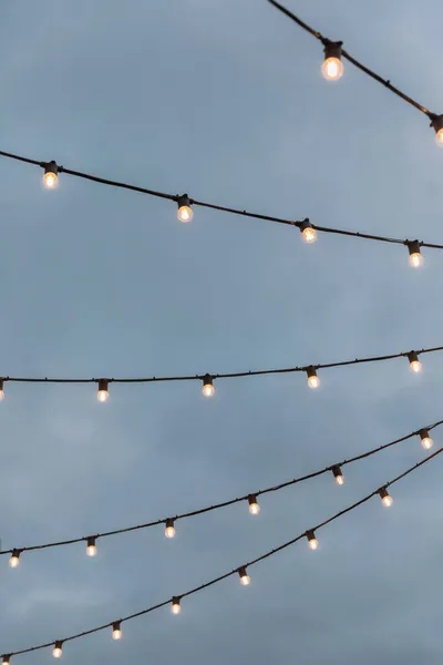 Ampul çelenkleri gri gökyüzüne karşı — Stok fotoğraf