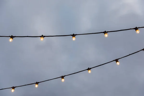 Гірлянди з лампочками на тлі сірого неба Ліцензійні Стокові Фото