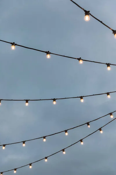 Гірлянди з лампочками на тлі сірого неба Ліцензійні Стокові Зображення
