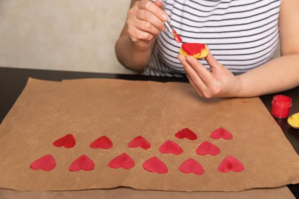 Sello de patata en forma de corazón en papel artesanal. El proceso de decorar un regalo para el Día de San Valentín. Preparándose para la celebración del 14 de febrero. — Foto de Stock