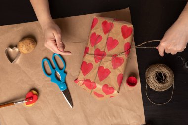 Kalp şeklinde bir patates pulu. Sevgililer Günü için bir hediye süsleme süreci. 14 Şubat 'taki kutlamaya hazırlanıyorum..