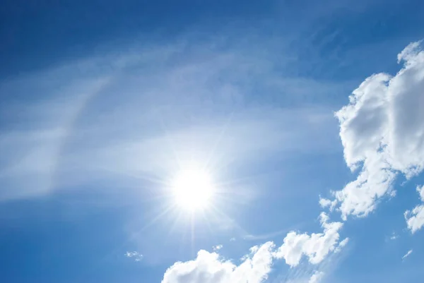 a solar halo brightens the blue sky on a summer day