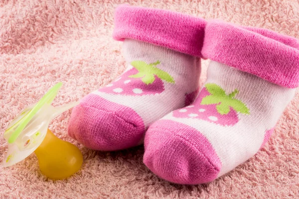 奶嘴和小小的粉红色袜子 — 图库照片