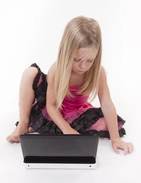 Маленька дівчинка працює на портативному комп'ютері — стокове фото