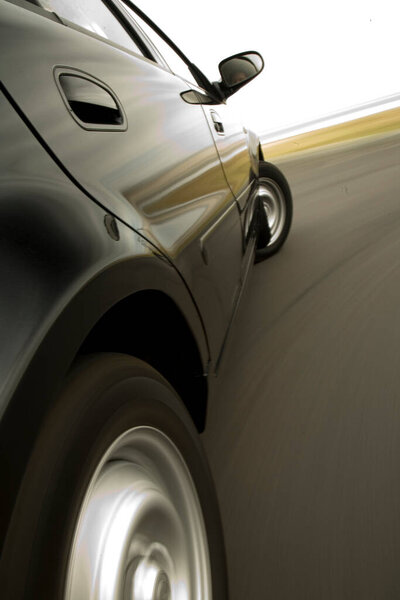 Черный автомобиль резко поворачивается вправо, показывая скорость отслеживания размытия.