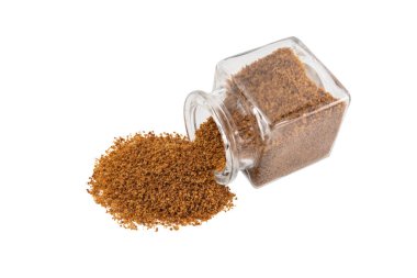 Beyaz arka planda izole edilmiş cam bir kavanozdan hindistan cevizi şekeri dökülüyor. Baharat ve yemek malzemeleri..