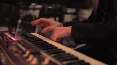 Siyahlı adamlar caz, soul, gece kulübünde rahatlama şarkıları söylüyorlar. Rahatlatıcı atmosfer. Piyano tuşlarında klavye sentezleyicisi çalan müzisyen. Müzisyen konser sahnesinde bir müzik aleti çalar.