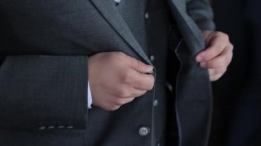 Siyah Takım Elbiseli İşadamı. Damat giyiniyor ve arka plandaki törene hazırlanıyor.