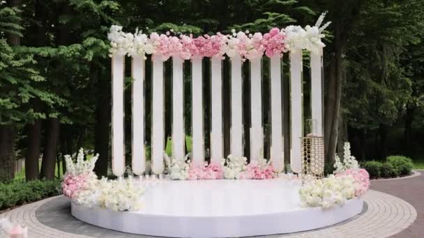 Frumos decor de nuntă. Arc de nuntă cu flori proaspete în ziua nunții însorite de vară. Decoratiuni de nunta cu flori in sala restaurantului — Videoclip de stoc