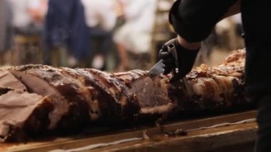 Parlak Işıkta Elle Pişirilmiş Et. Şef Modern Mutfağa Eşlik Ediyor, Özel Yemek Tarifi. Önlüklü aşçı büyük kızarmış et parçasını kesme tahtasına koyar. Lezzetli ve lezzetli et pişirmek.