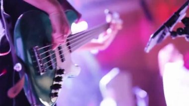 Canlı performans sırasında gitar çalan bir müzisyen. Elektro gitar tıngırdatıyorum. Bir müzisyen müzik çalar. Elektro gitarla çalan insan eli. Gitar tellerinde parmaklar.