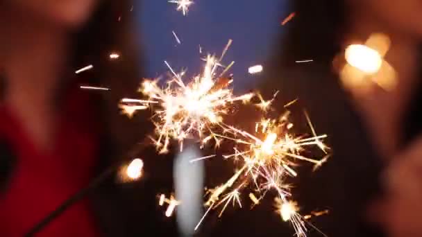 Close-up Hände halten Wunderkerzen Gruppe von Freunden feiern winkende Wunderkerzen Feuerwerk tanzen genießen Silvesterparty Spaß Urlaub Feier am Abend. Bengalisches Flackern verschwommen Bokeh. — Stockvideo