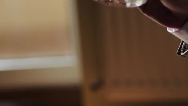 Aantrekkelijke zakenman met een glas whisky in een donkere kamer. Closeup van executive holding whiskey ter illustratie van executive privilege concept. — Stockvideo