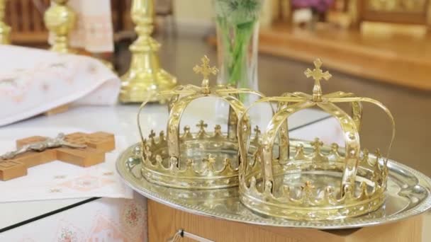 Dos coronas de boda en la iglesia. Corona dorada en el altar de la iglesia. Ceremonia de boda tradicional. Religión. — Vídeo de stock