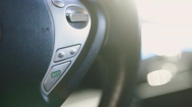Elektrikli araba sürücüsü, eko düğmeye basıyor, direksiyon simidi, çevre koruması. Elektrikli arabadaki eko tuşuna bas. Erkek el elektrikli araba tekerleğini çeviriyor. Kapatın, modern aracı çalıştırın.