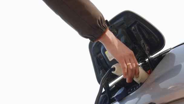 Electric vehicle charging port. Mans hands unplugging her electric automobile. Male hand plugging out the electric car charger. A shot under the hatch where the electric eco car charges — Stock Video