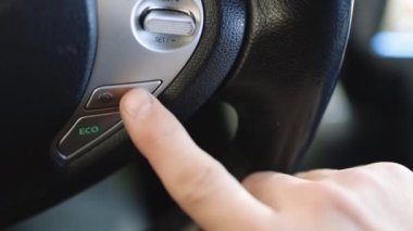 İşadamı otomatik kontrollü otomatik pilotu çalıştırmak için düğmeye basıyor otomatik çalışan elektrikli arabayı kontrol ediyor. Kentin Otobanında Otomatik Sürücü Otomobil Gidiyor