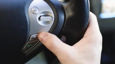 Sürücü, kırsal kesimde manzaralı yolda giderken otonom bir arabanın seyir kontrolünü kuruyor. Direksiyon düğmesi bir araba sürerken uyarlanabilir Cruise Control