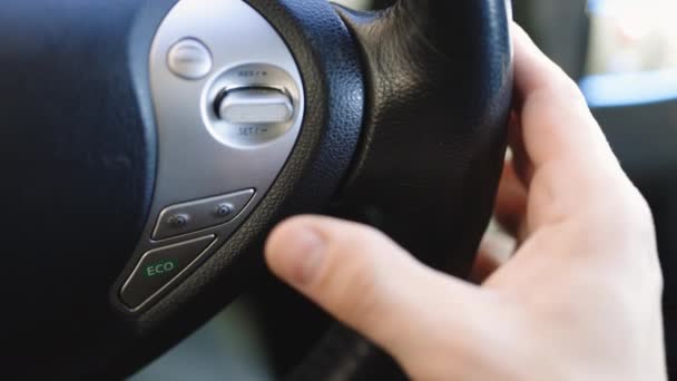 Палец нажимает кнопку, чтобы запустить автономный круиз-контроль автопилота. Кнопка руля адаптивного круиз-контроля во время вождения автомобиля. Концепция транспортировки — стоковое видео