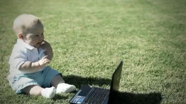 bir defter ile çim üzerinde bebek sittind
