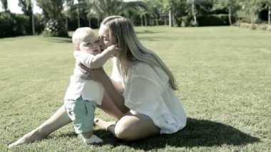 Bebek anne parkta çim ile oyunu