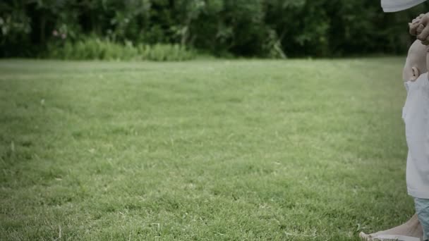 Mignon petit bébé pour une promenade dans un parc ensoleillé . — Video