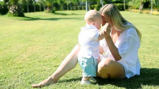 Baby funning with mother on the grass in park — Stock Video