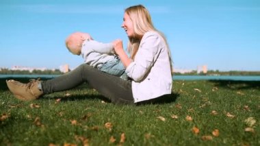 Bebek anne parkta çim ile oyunu