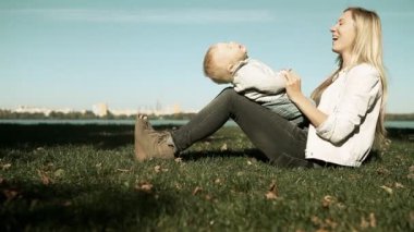 Bebek anne parkta çim ile oyunu