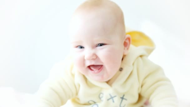 Sonriente bebé en el fondo claro — Vídeo de stock