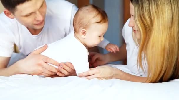 Glückliche Familie: Vater, Mutter und Baby verspielt im Schlafzimmer — Stockvideo