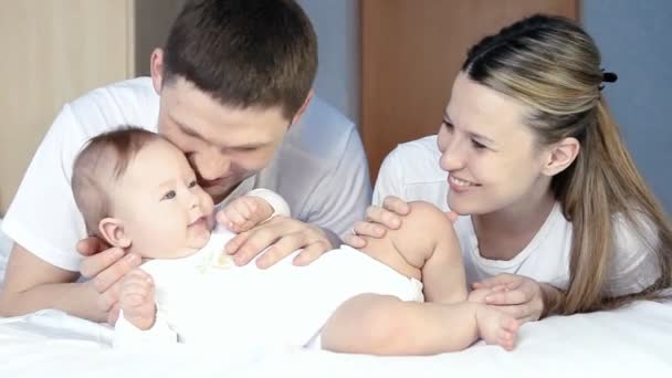 Glückliche Familie: Vater, Mutter und Baby verspielt im Schlafzimmer — Stockvideo