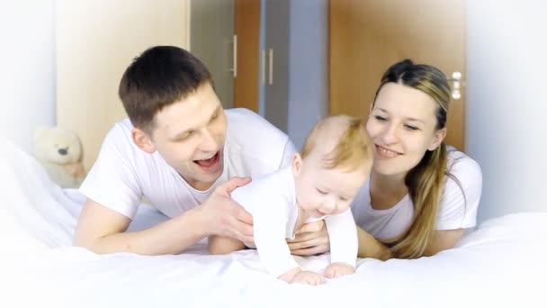 Glückliche Familie: Vater, Mutter und Baby verspielt im Schlafzimmer — Stockvideo