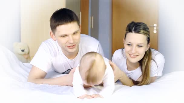 Happiness family: father, mother and baby playful on the bedroom — Stock Video