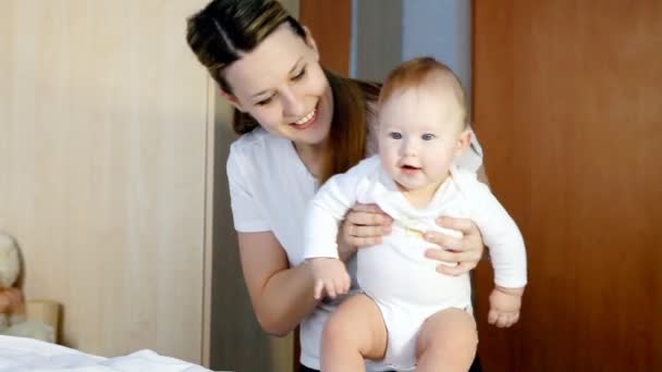 Glückliche Familie: Vater, Mutter und Baby verspielt im Schlafzimmer — Stockvideo