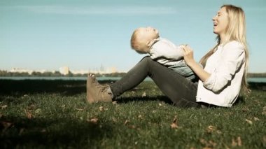 Bebek anne parkta çim ile oyunu