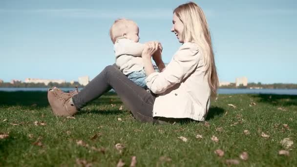 Baby funning with mother on the grass in park — Stock Video