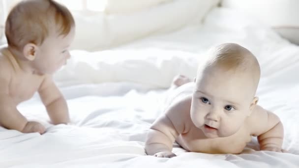 Deux bébés heureux s'amusent sur le lit — Video