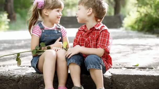 Two child speaking and boy present flower — Stock Video