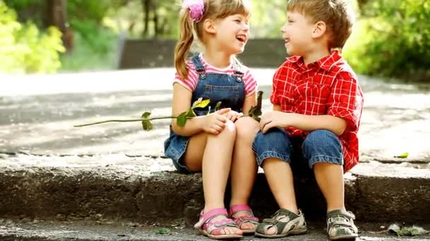 Two child speaking and boy present flower — Stock Video