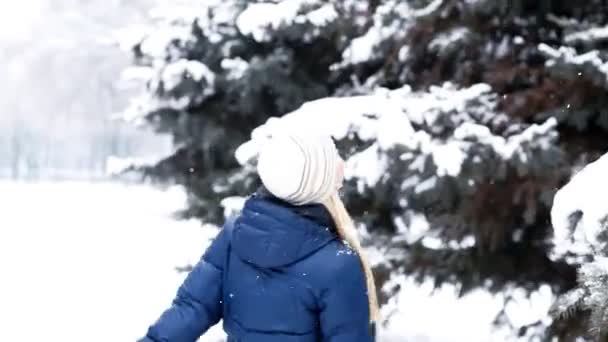 Счастливая девочка гуляет в зимнем лесу — стоковое видео