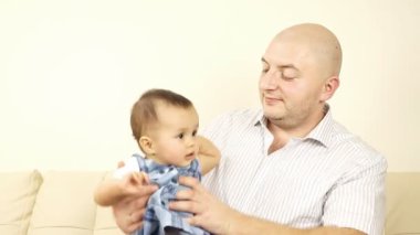 kanepede oturan babası ile gülen bebek