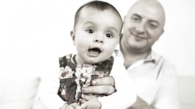 kanepede oturan babası ile gülen bebek