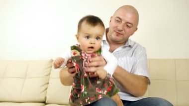 kanepede oturan babası ile gülen bebek