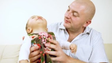 kanepede oturan babası ile gülen bebek