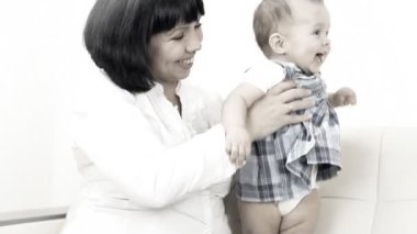 kanepede oturan annesi ile gülen bebek