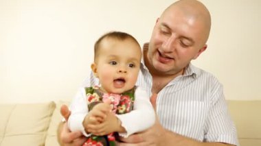 kanepede oturan babası ile gülen bebek